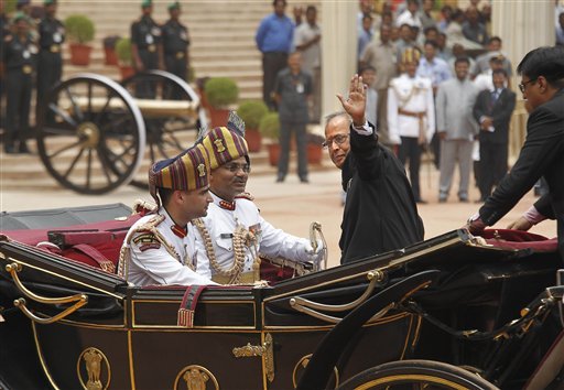 India's new President Pranab Mukherjee, in a traditional horse driven carriage, waves to the media as he arrives at the Presidential Palace, in New Delhi, India, Wednesday, July 25, 2012. Escorted by the President's bodyguards in white-uniforms, Mukherjee, 76, was sworn in Wednesday as India's 13th president in an elaborate ceremony in Parliament. (AP Photo/Manish Swarup) 
