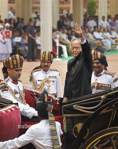 India's new President Pranab Mukherjee, in a traditional horse driven carriage, waves to the media as he arrives at the Presidential Palace, in New Delhi, India, Wednesday, July 25, 2012. Escorted by the President's bodyguards in white-uniforms, Mukherjee, 76, was sworn in Wednesday as India's 13th president in an elaborate ceremony in Parliament. (AP Photo/Manish Swarup) 
