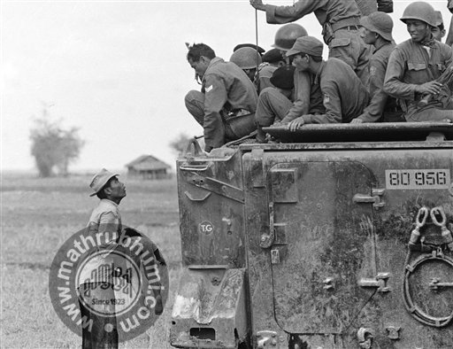  In this March 19, 1964 file photo, one of several shot by Associated Press photographer Horst Faas which earned him the first of two Pulitzer Prizes, a father holds the body of his child as South Vietnamese Army Rangers look down from their armored 
