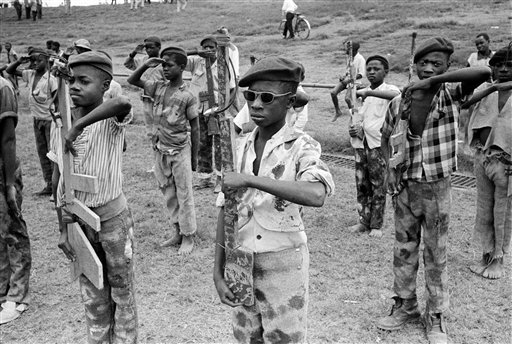 In this Nov. 28, 1961 file photo taken by Associated Press photographer Horst Faas, boys belonging to the Katangese Youth Movement, wearing improvised uniforms of their own design, drill with homemade wooden rifles in the native quarter of Elisabethv
