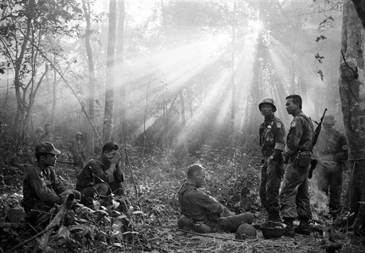  In this January 1965 file photo taken by Associated Press photographer Horst Faas, the sun breaks through dense jungle foliage around the embattled town of Binh Gia, 40 miles east of Saigon, as South Vietnamese troops, joined by U.S. advisers, rest 
