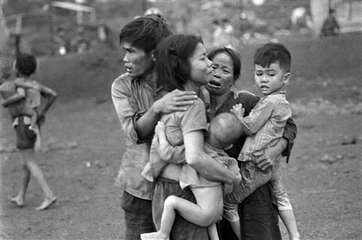  In this June 1965 file photo shot by Associated Press photographer Horst Faas, South Vietnamese civilians, among the few survivors of two days of heavy fighting, huddle together in the aftermath of an attack by government troops to retake the post a
