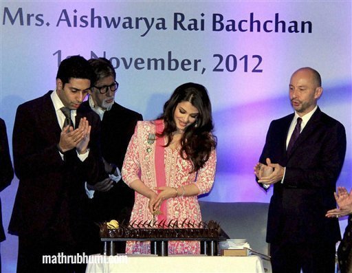 Bollywood actress Aishwarya Rai Bachchan offers cake to her husband actor Abhishek Bachchan as her mega actor Amitabh Bachchan looks on during her birthday celebration in Mumbai on Thursday. Aishwarya was conferred with the French civilian award, Officer Dan Ordre Arts et des Lettres at the function. PTI Photo 
