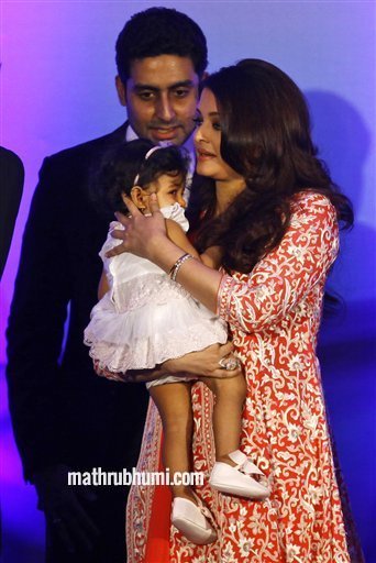 Bollywood actress Aishwarya Rai Bachchan holds her daughter Aaradhya as her husband actor Abhishek Bachan walks with her during a function where she received the second highest French civilian award 'Officer Dan Ordre Arts et des Lettres', in Mumbai, India Thursday, Nov 1, 2012 
