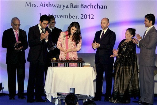 Bollywood actress Aishwarya Rai Bachchan cuts a cake on her birthday as her husband Abhishek Bachchan, father-in-law Amitabh Bachchan and French Ambassador to India, Francois Richier (3rd R) applaud at a function in Mumbai on Thursday. Aishwarya was conferred with the French civilian award, Officer Dan Ordre Arts et des Lettres at the function. PTI Photo 
