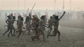 Juna Akhara Naga sadhus run to take bath at Sangam, the confluence of the Ganges, Yamuna and mythical Saraswati river, during the the first royal bath on Makar Sankranti

